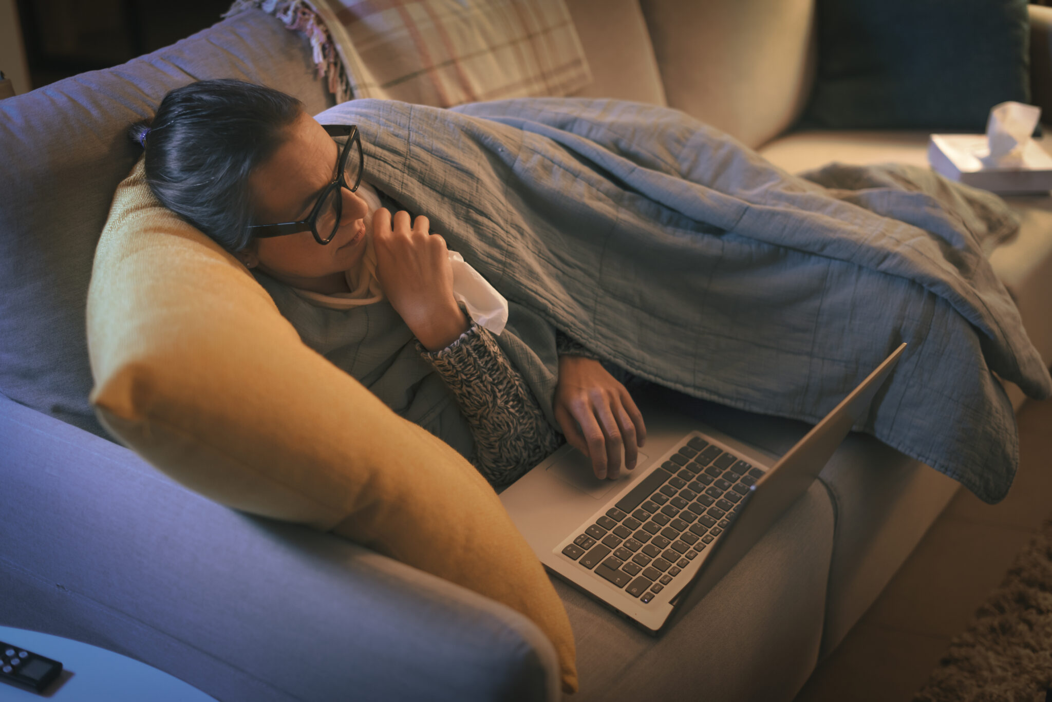 Sick woman with flu connecting with her laptop
