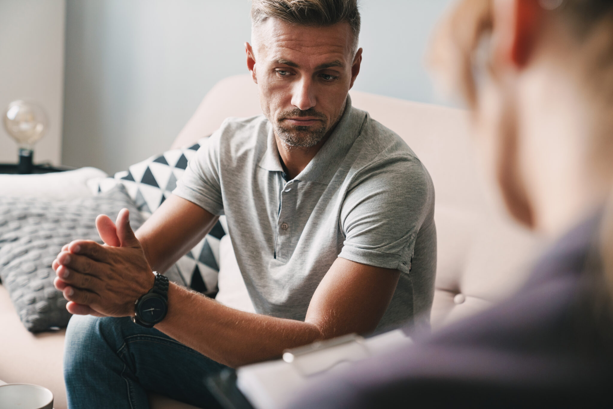 Photo of brooding unshaven man having conversation with psycholo